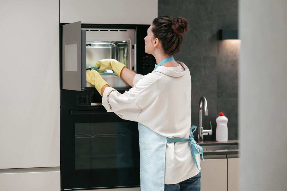 Woman with yellow gloves caring for micorwave