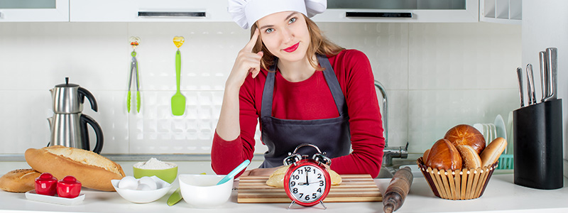 Woman in kitchen waiting for timer